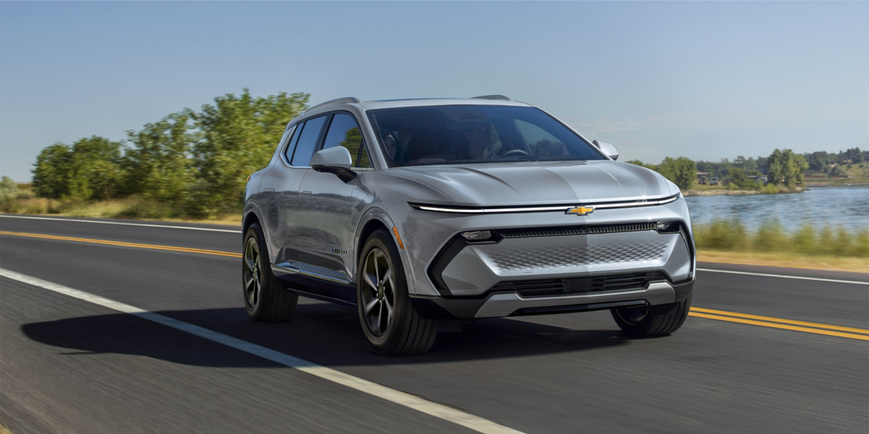 Chevrolet Equinox EV Driving on a Road Beside a Lake