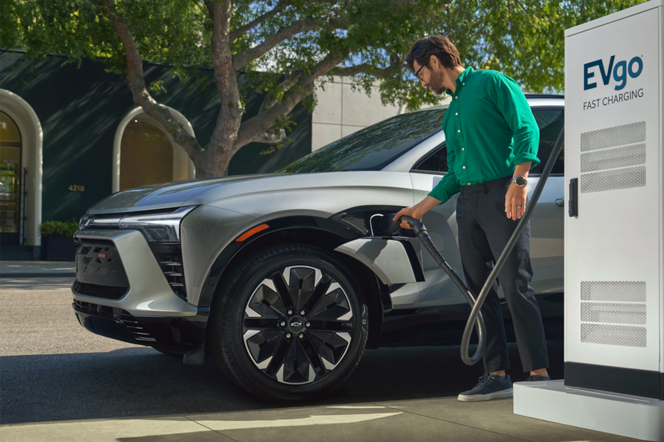 A Man Plugging in His Blazer EV at a Public Charging Station