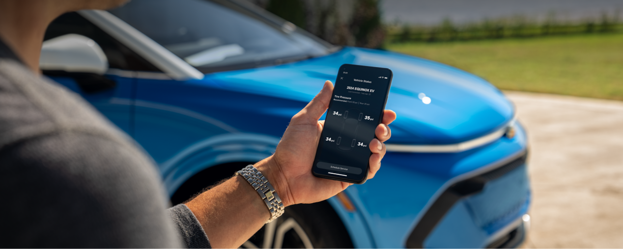 A Man Holds a Phone with the Vehicle Status on the Screen