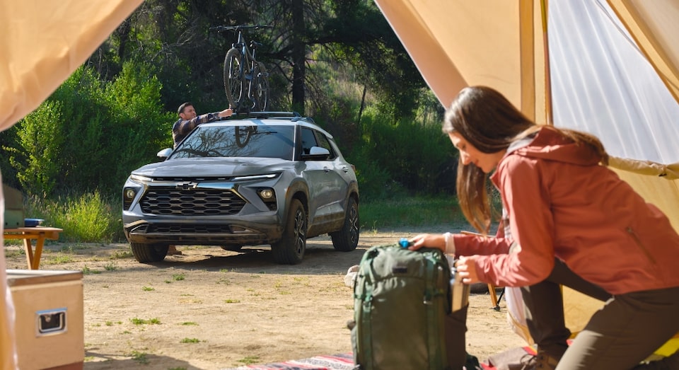 A Chevy SUV Parked outside a tent with woman in the Country