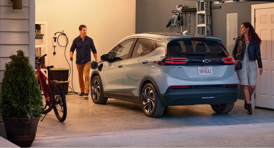 A Couple Standing in Their Garage Near Their Chevrolet Bolt EV