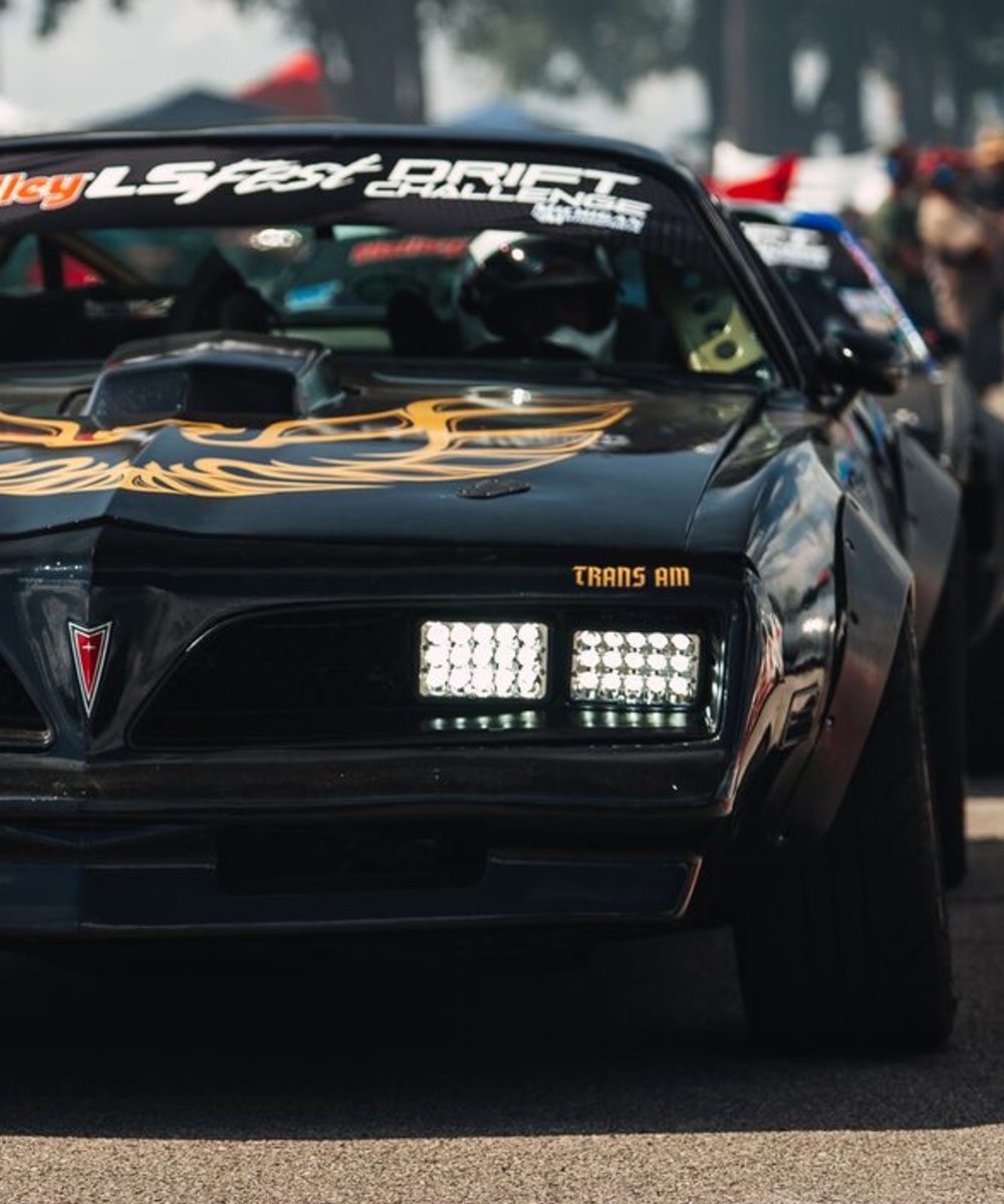 Front View of a Black Pontiac Trans Am on a Racetrack