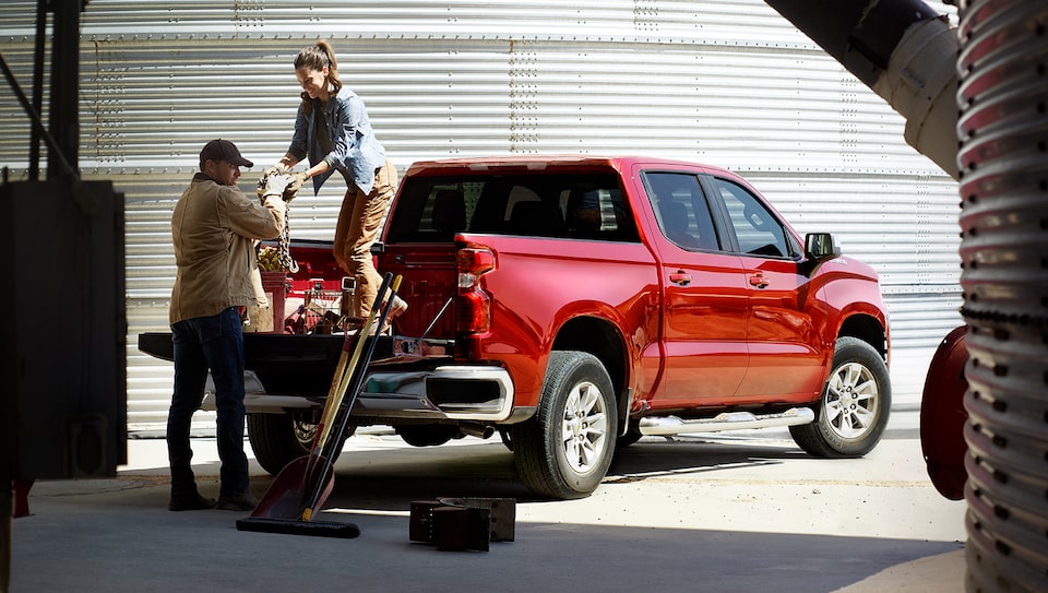 Farm Workers Unloading Equipment from the Bed of Chevrolet Silverado Truck