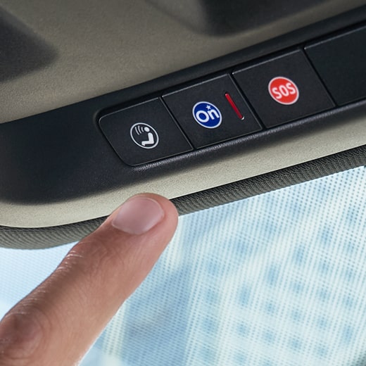 Driver Pressing OnStar Services Button in Chevrolet Vehicle