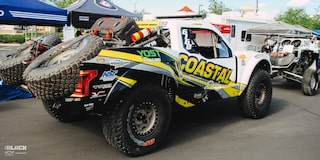 Rear Three-Quarters View of Jake Velasco's Off-Roading Truck Parked Near A Couple Tents and RVs