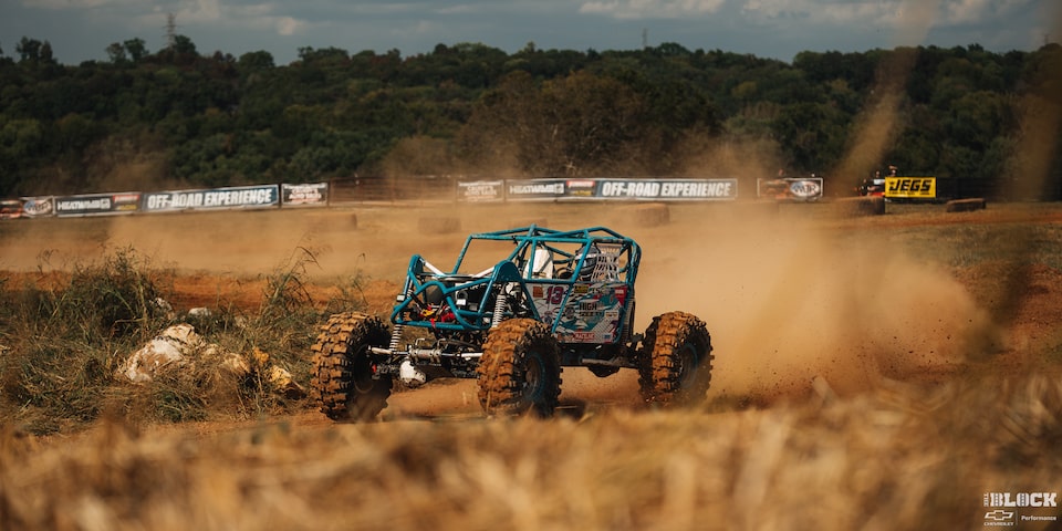 Three Quarters View of an Off-Road Vehicle Going down the Trail on a Sunny Day Leaving behind Dust