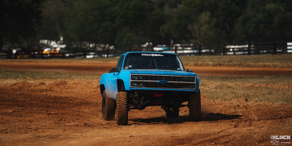 Front View of a Blue Chevy Pickup Truck Making a U-Turn on a Trail under a Sunny Day