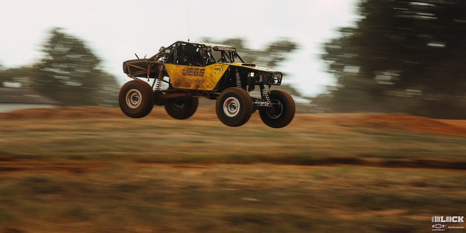 Side View of an Off-Road Vehicle in the Air for a Brief Moment Due to Speeding through the Trail