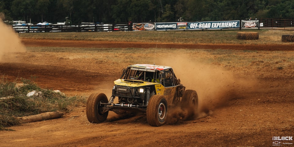 Three Quarters View of an Off-Road Vehicle Speeding with Dust Flying from the Rear